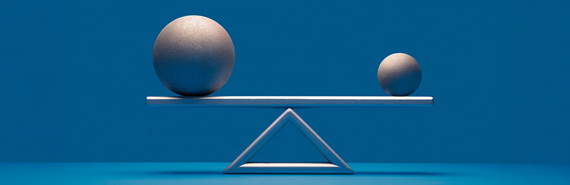 A balanced scale with two metallic spheres of different sizes resting on a horizontal beam, symbolizing the strategic transfer of wealth and tax efficiency often associated with intentionally defective grantor trusts (IDGTs).